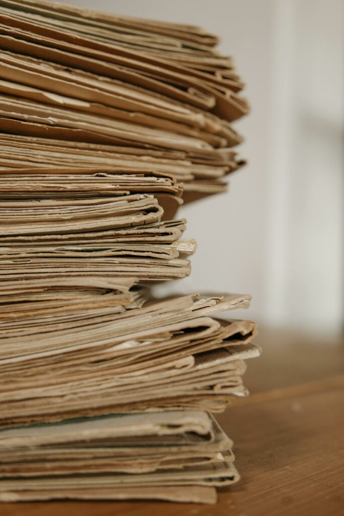 pexels-photo-7654130-7654130 Aide à la facturation artisan loiret-up of vintage paper stacks on a wooden table, evoking a classic office setting.